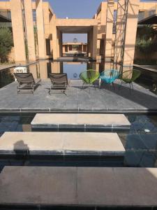 a group of chairs sitting next to a swimming pool at Marrakech Holiday in Marrakesh