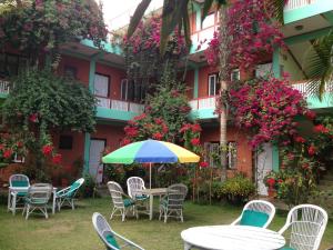 a table and chairs with an umbrella in front of a building at New Pokhara Lodge - Lakeside, Pokhara Nepal in Pokhara
