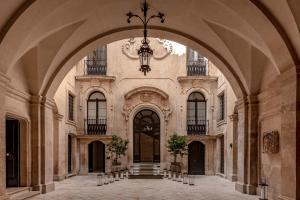 un ingresso a un edificio con lampadario pendente di La Fiermontina Palazzo Bozzi Corso Hotel a Lecce
