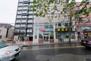 a street with a store on the side of a building at Dynasty Hotel and Suites New York LaGuardia Hotel in Queens
