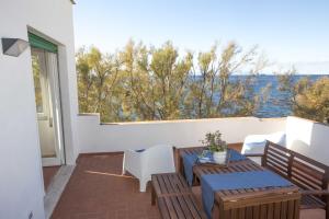 a patio with a table and chairs and a view of the water at Casa Bianca - Goelba in Pomonte