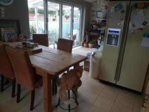 a dog standing around a wooden table in a kitchen at The garden room, pets, fridge Tv in Chester
