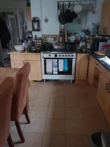 a kitchen with a stove and a table in it at French doors garden pets fridge Tv in Chester