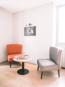 a living room with two chairs and a table at Hôtel de la Rhune in Ascain