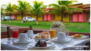 博尼圖的住宿－Pousada Voo das Garças，餐桌上放有食物和橙汁