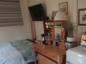 a bedroom with a bed and a desk with a television at French doors garden pets fridge Tv in Chester