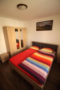 een slaapkamer met een bed met een kleurrijk gestreepte deken bij Orion in Predeal