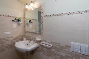 a bathroom with a sink and a mirror at La Cycas Accommodation in Tropea