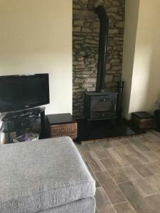 a living room with a stone fireplace and a couch at Ash Lodge Leitrim Village in Leitrim