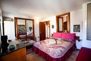 1 dormitorio con cama con sábanas rosas y escritorio en Antica Molina en Faggeto Lario 