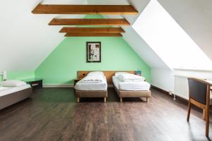 two beds in a room with a attic at Hotel am Schillerplatz in Pleidelsheim