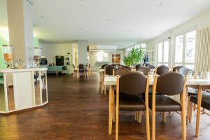 ein Esszimmer mit Tischen und Stühlen in einem Zimmer in der Unterkunft Hotel am Schillerplatz in Pleidelsheim