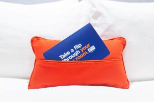 a blue and orange pillow with a card on it at Holiday Inn Express - London Heathrow T4, an IHG Hotel in Hillingdon