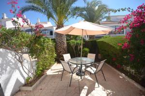 a table and chairs with an umbrella on a patio at APCOSTAS - Gran Vista in Gran Alacant