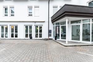 een winkel met glazen deuren in een straat bij Hotel am Schillerplatz in Pleidelsheim