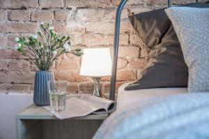 a bed with a table with a glass and a lamp at LION apartments - SILVER in Kraków