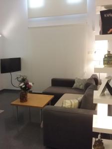 ein Wohnzimmer mit einem Sofa und einem Tisch in der Unterkunft Agnanti Apartments in Argaka