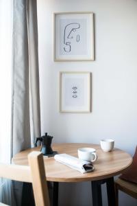 a wooden table with two cups and two pictures on the wall at LION apartments - SILVER in Kraków