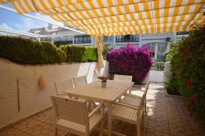 a table and chairs under an umbrella on a patio at APCOSTAS - Gran Vista in Gran Alacant