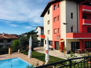 Blick auf ein Gebäude und einen Swimmingpool mit Sonnenschirmen in der Unterkunft Hotel Opera' in Moscufo