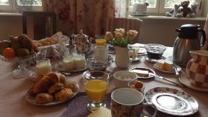 a table with a breakfast of eggs bread and orange juice at Le Domaine De Pomone in Woinville