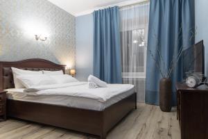 モスクワにあるFortNight 4 near Radisson-2 roomsのベッドルーム1室(青い壁と青いカーテンのベッド1台付)