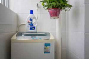 a bottle of detergent sitting on top of a tank in a bathroom at Jinan Shizhong·Baotu Spring· Locals Apartment 00113540 in Jinan
