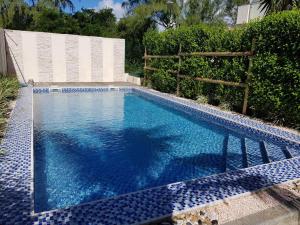 een zwembad met een blauwe tegelvloer en een hek bij Le KatoBay Residence in Pereybere