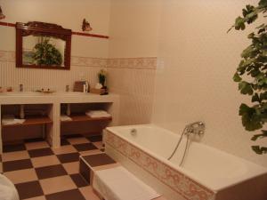 y baño con bañera y lavamanos. en Le Domaine De Pomone, en Woinville