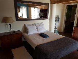 Schlafzimmer mit einem Bett und einem Spiegel an der Wand in der Unterkunft A Casinha da Baía in Porto Covo