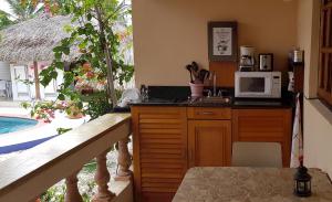 uma cozinha com um lavatório e um micro-ondas no balcão em Villa Punta Salina em Palm-Eagle Beach