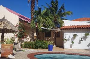 una casa con piscina frente a ella en Villa Punta Salina, en Palm-Eagle Beach