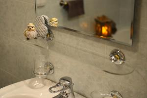 a bathroom sink with a mirror and a glass at Miraval Perathoner Andreas in Ortisei