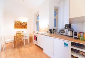 a kitchen with white cabinets and a table with chairs at Rembrandt Refugium in Vienna