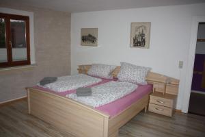 1 dormitorio con cama de madera y colchón morado en Gästehaus Wacker en Ringsheim