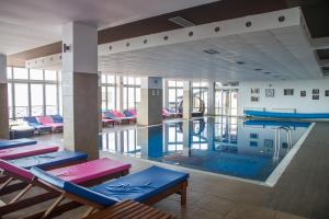 a large swimming pool with tables and chairs in a building at MISS Premier 19 Milmari in Kopaonik