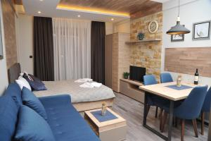 a room with a bed and a table and blue chairs at MISS Premier 19 Milmari in Kopaonik