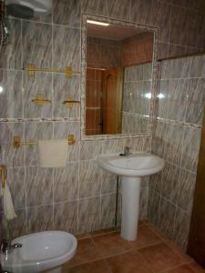 W łazience znajduje się umywalka, toaleta i lustro. w obiekcie Casas Cueva Paloma w mieście Los Carriones