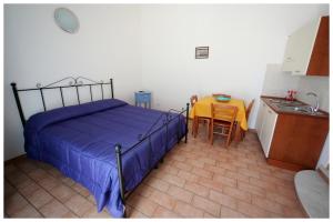 1 dormitorio con 1 cama y cocina con mesa en Plaia Case Vacanza, en Favignana