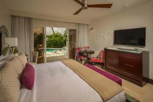 a bedroom with a bed and a flat screen tv at Sandals Halcyon Beach All Inclusive - Couples Only in Vigie
