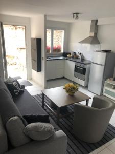 cocina y sala de estar con sofá y mesa en JOLIE PETITE MAISON en Villepinte