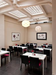 a dining room with white tables and chairs at Hotel PurPur in Prague