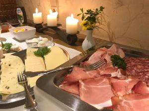 einen Tisch mit einem Tablett mit Fleisch und Kerzen in der Unterkunft Pension und Ferienwohnung Schütte in Schmallenberg