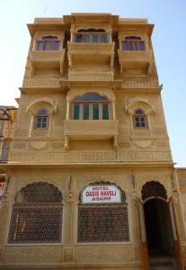 a building with a sign on the side of it at Hotel Oasis Haveli in Jaisalmer