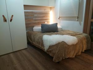 Un dormitorio con una cama con una almohada encima. en Appartamento Campiglio, en Madonna di Campiglio