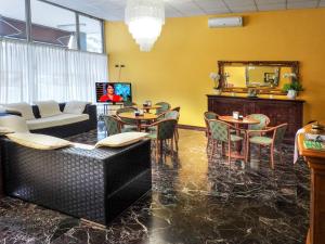 - un salon avec des tables, des chaises et un canapé dans l'établissement Hotel Select, à SantʼIlario dʼEnza