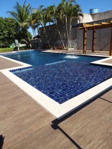 a swimming pool with a fountain in a backyard at Pousada Voo das Garças in Bonito