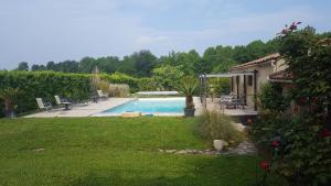 un patio trasero con piscina y una casa en Chambres d'hôtes Les Palmiers de la Cité, en Carcassonne