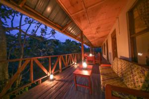 un balcone di una casa con un divano su una terrazza di Gorilla Closeup Lodge a Kisoro