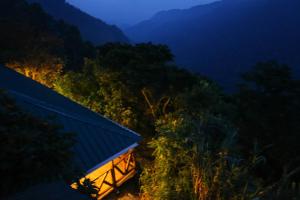 a view of a house in the mountains at night at Gorilla Closeup Lodge in Kisoro